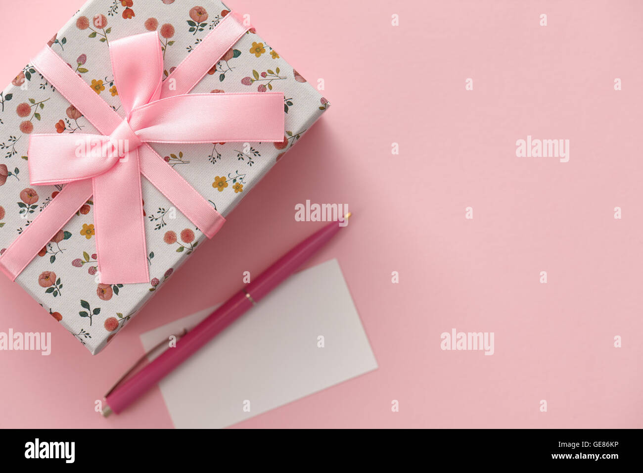 Boîte cadeau motif floral sur fond rose Banque D'Images