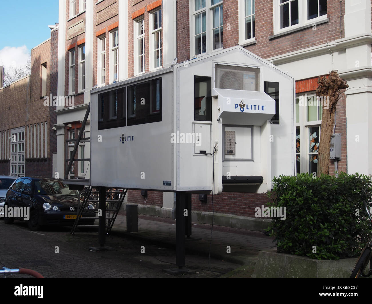 Une photographie historique montrant la rue Gérard Doustraat à Amsterdam, capturant les bâtiments de la rue et la présence d’un poste de police, révélateur de la vie urbaine au début du XXe siècle aux pays-Bas. Banque D'Images