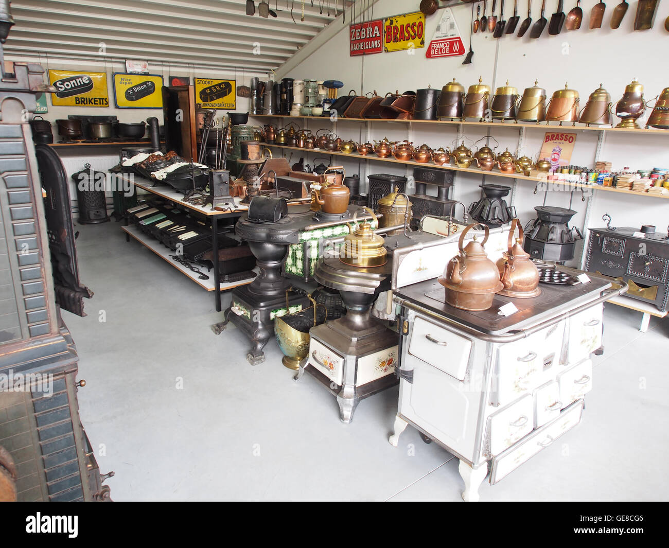 Cette image historique capture le département de *Kachels en Stoven*, qui fait référence à la section des poêles à tuiles dans un musée néerlandais. Il présente des poêles en céramique anciens et des appareils de chauffage carrelés des siècles passés. Banque D'Images