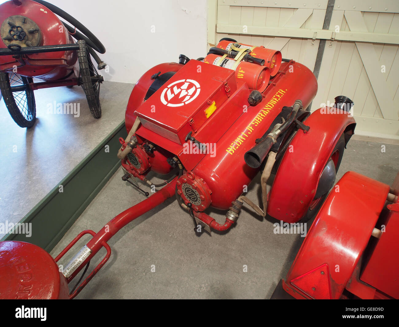 Cette image représente une vieille machine à incendie à poudre, utilisée dans le passé pour la lutte contre les incendies. Le moteur de pompiers vintage, avec sa conception classique et ses caractéristiques mécaniques, reflète les premières technologies et pratiques de lutte contre les incendies. Banque D'Images