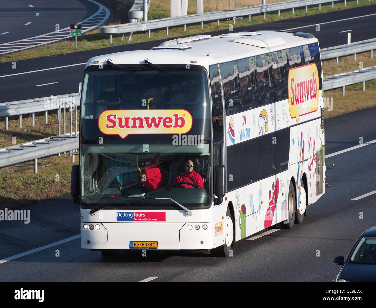 Une photographie d'un autocar Sunweb de Jong Tours, montrant le véhicule de voyage moderne utilisé pour les visites et les transports. L'autocar est représenté dans un cadre pittoresque, reflétant les services de l'agence de voyage qui offrent des excursions guidées à travers diverses destinations. Banque D'Images