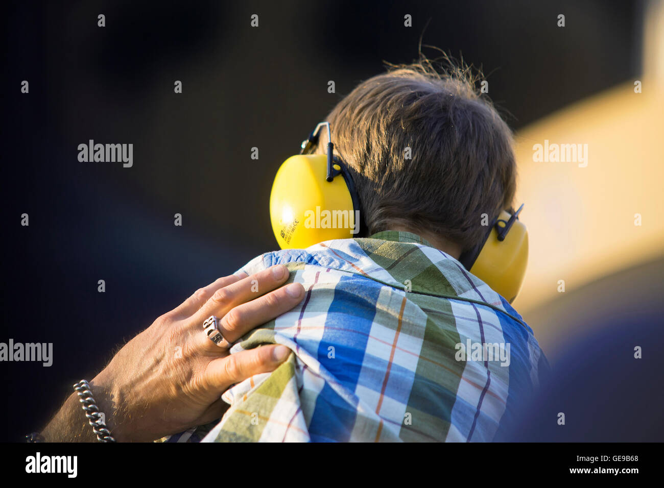 Boy wearing protection auditive lors de concert en plein air. Banque D'Images