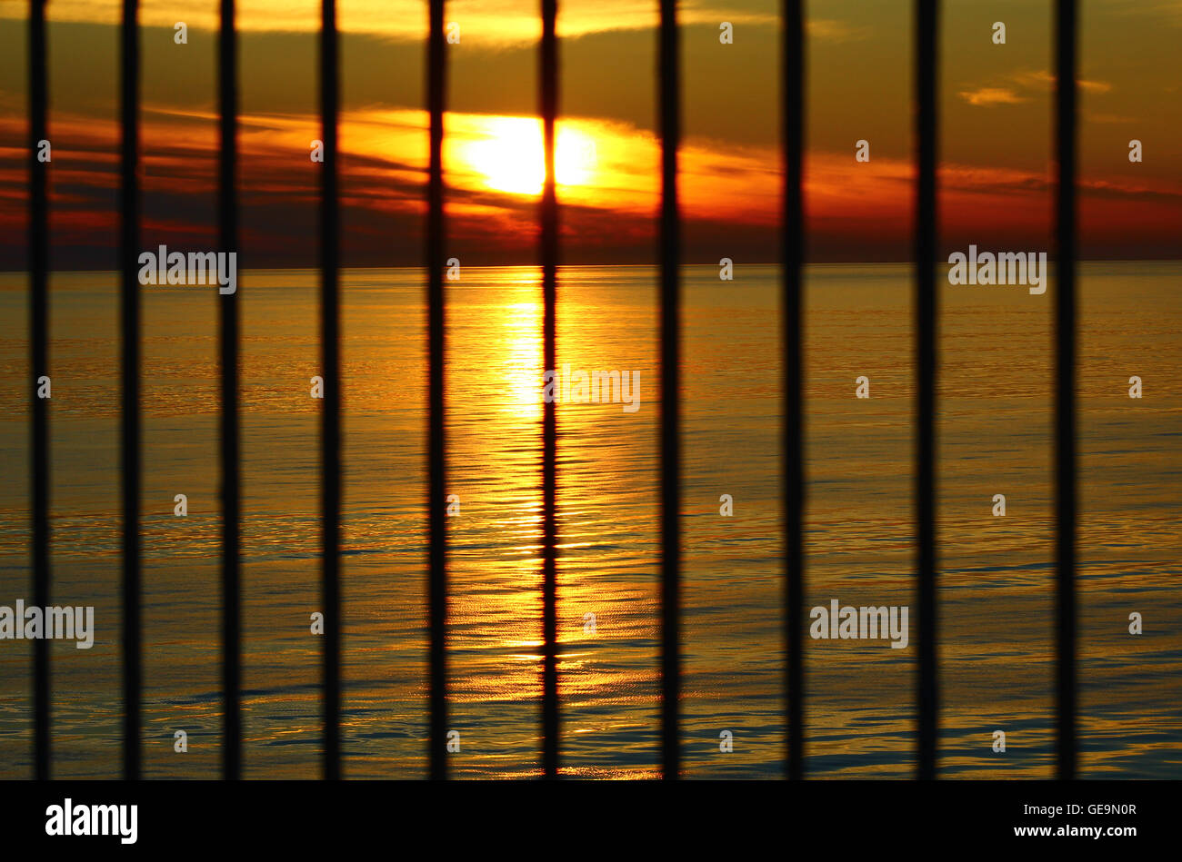 Le coucher du soleil le soir à la mer Baltique derrière les barreaux Banque D'Images