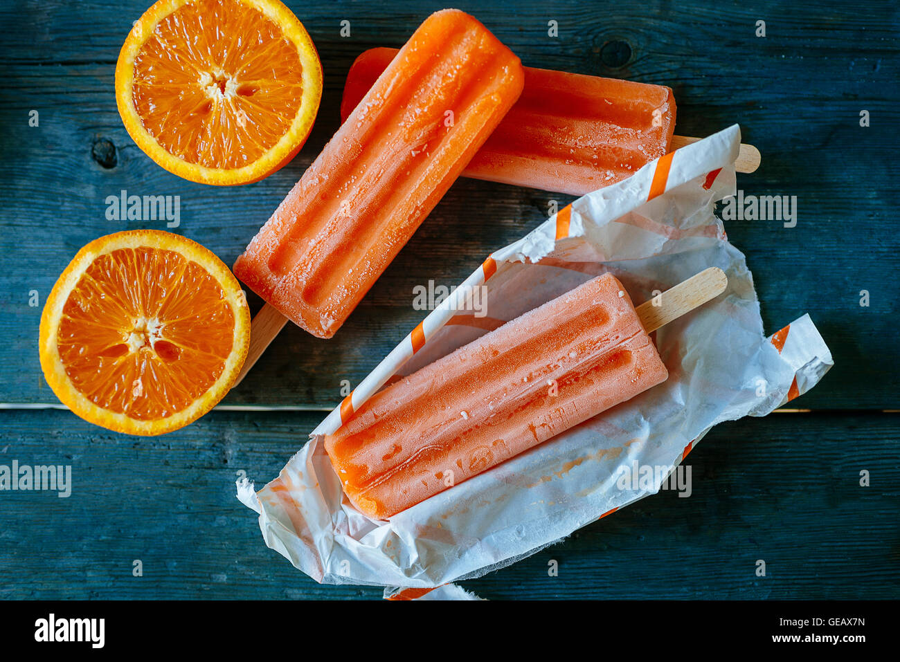 La neige Orange la crème glacée dans des emballages et des oranges sur bois Banque D'Images