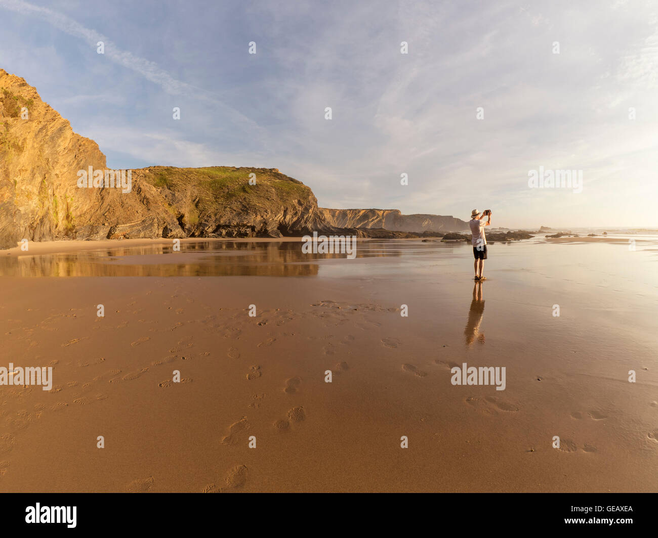 Le Portugal, Senior man standing at beach taking picture with digital tablet Banque D'Images