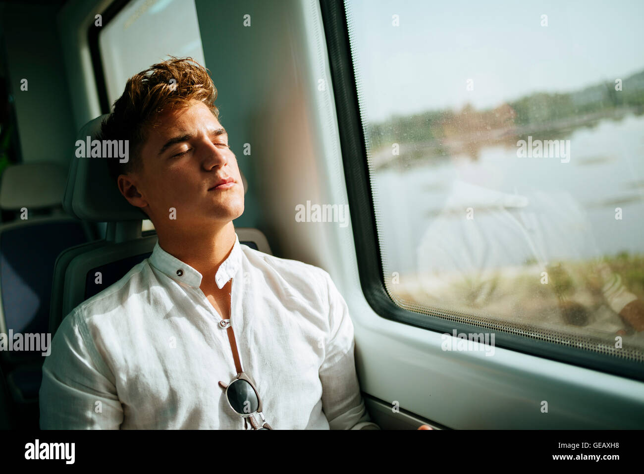 Jeune homme dormir sur un train Banque D'Images