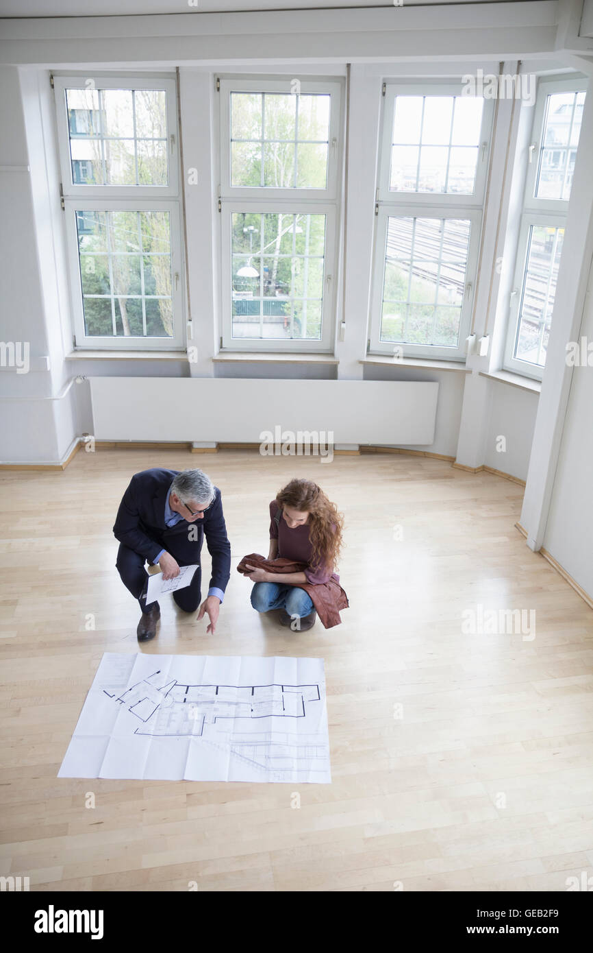 Agent immobilier construction montrant l'intention de client en appartement vide Banque D'Images