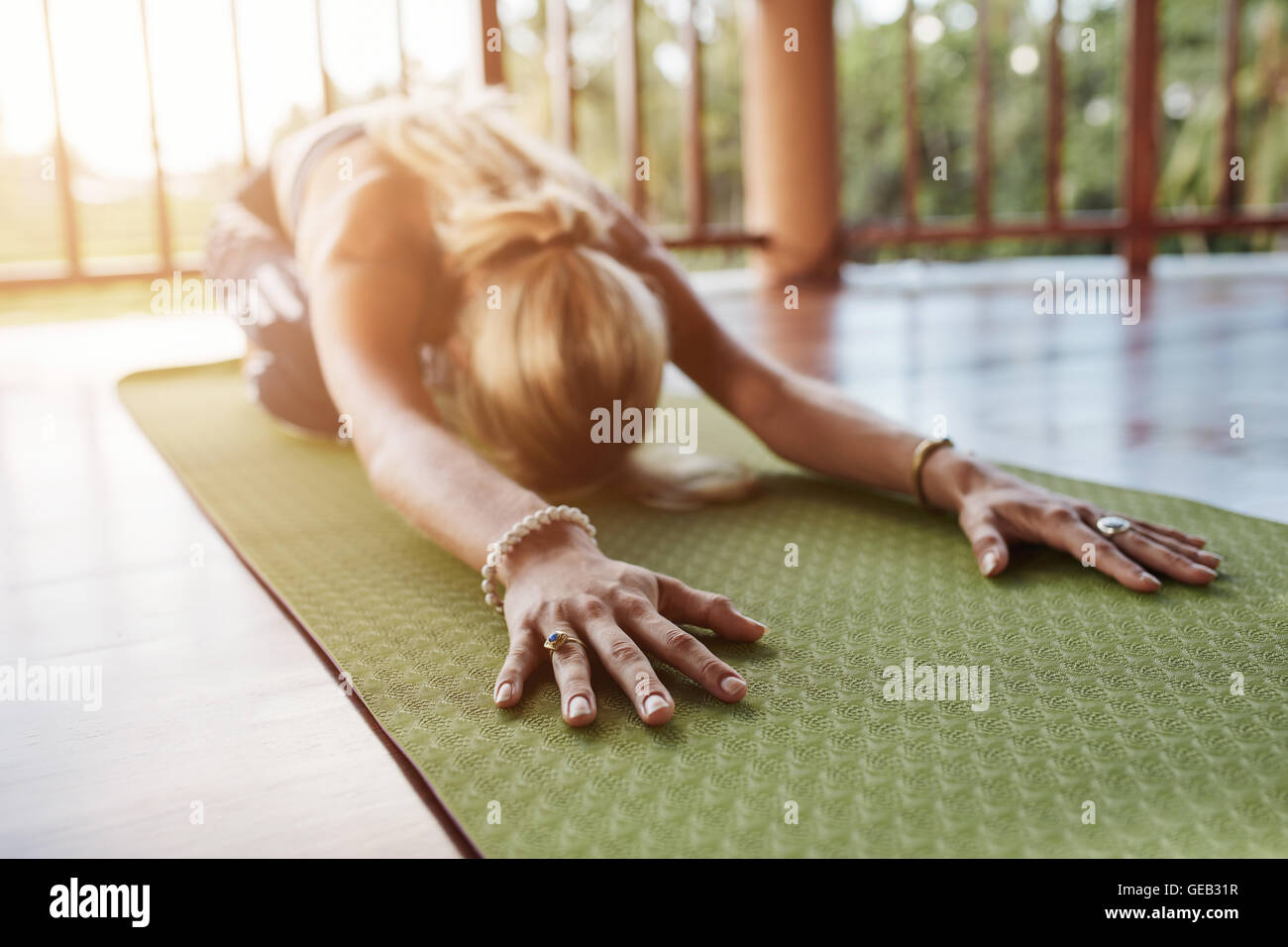 Portrait de l'avant, effectuer une pose de yoga sur tapis d'exercice. Femme Fitness yoga sport balasana à effectuer, l'accent sur les mains Banque D'Images