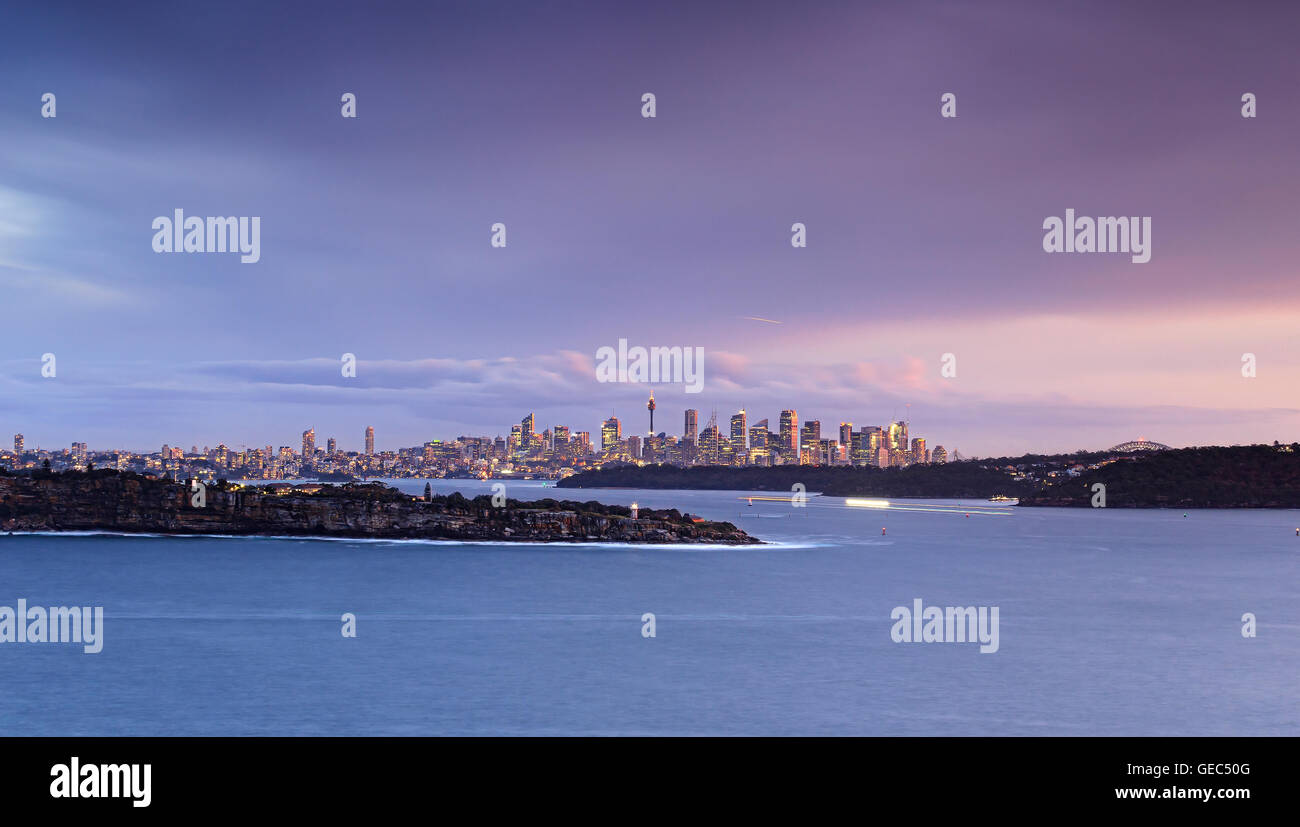Panorama de l'entrée du port de Sydney derrière la tête du Sud avec Phare et city CBD en arrière-plan lointain au coucher du soleil Banque D'Images