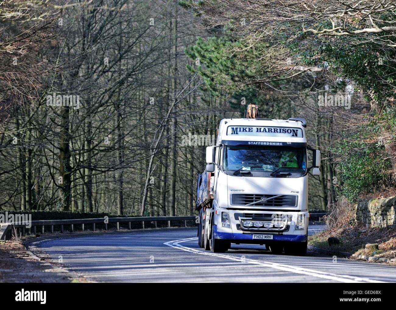 Un camion du marchand pour la construction, l'arrondissement d'un virage sur l'A57 Snake Pass avec les arbres d'automne en arrière-plan Banque D'Images Un camion du marchand pour la construction, l'arrondissement d'un virage sur l'A57 Snake Pass avec les arbres d'automne en arrière-plan Banque D'Images