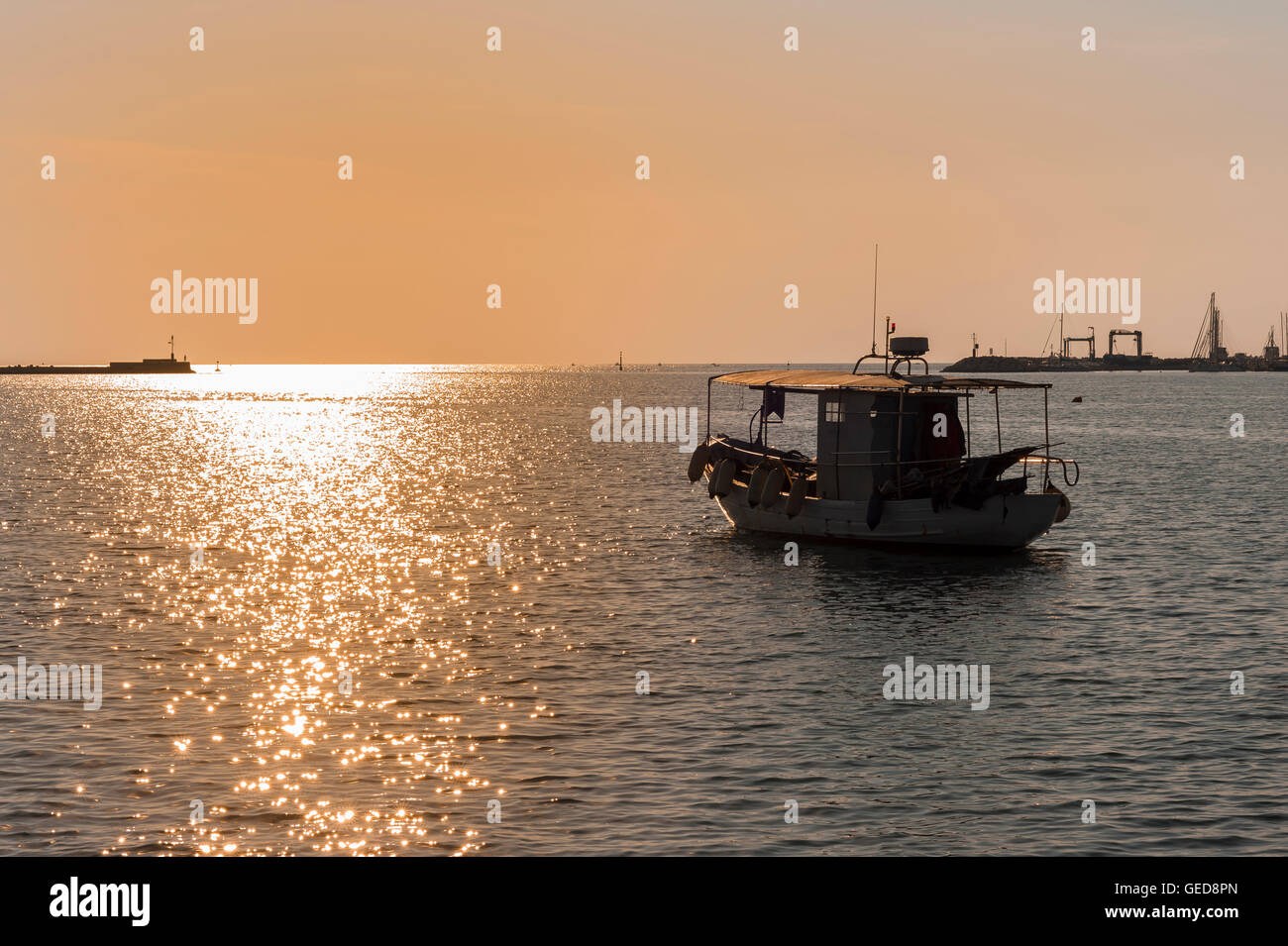 Bateau de pêche professionnel quitte le port au coucher du soleil Banque D'Images