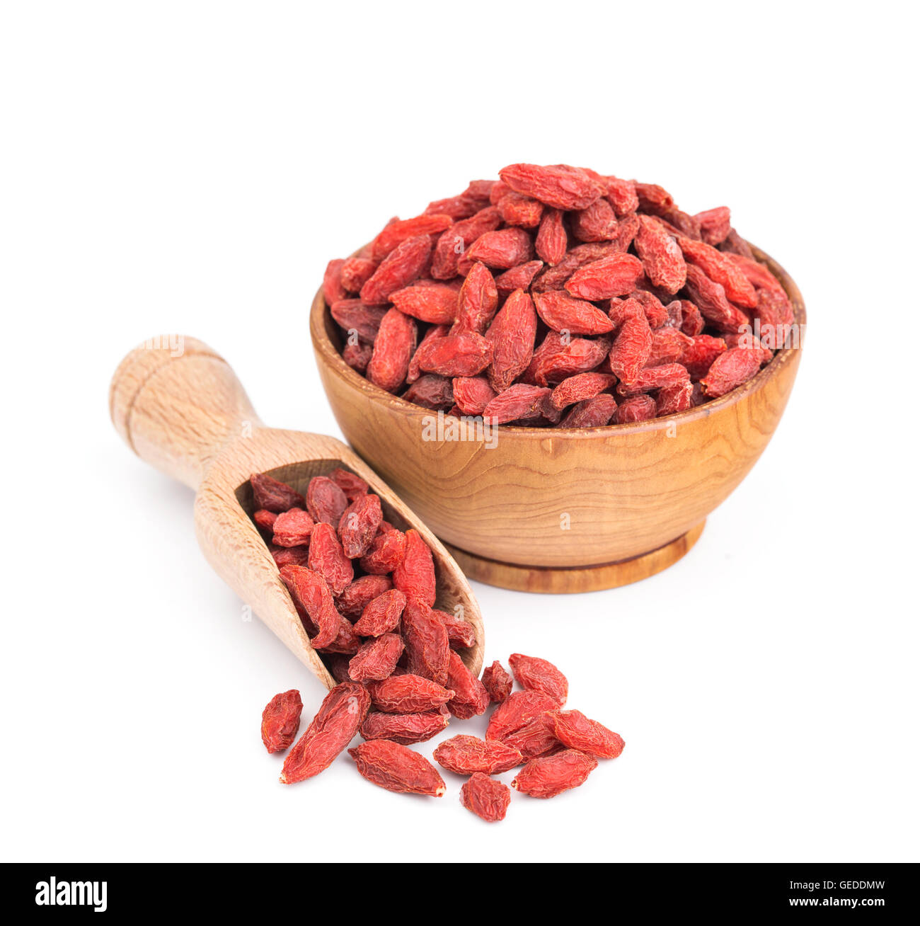 Les baies de goji dans un bol en bois isolé sur blanc Banque D'Images