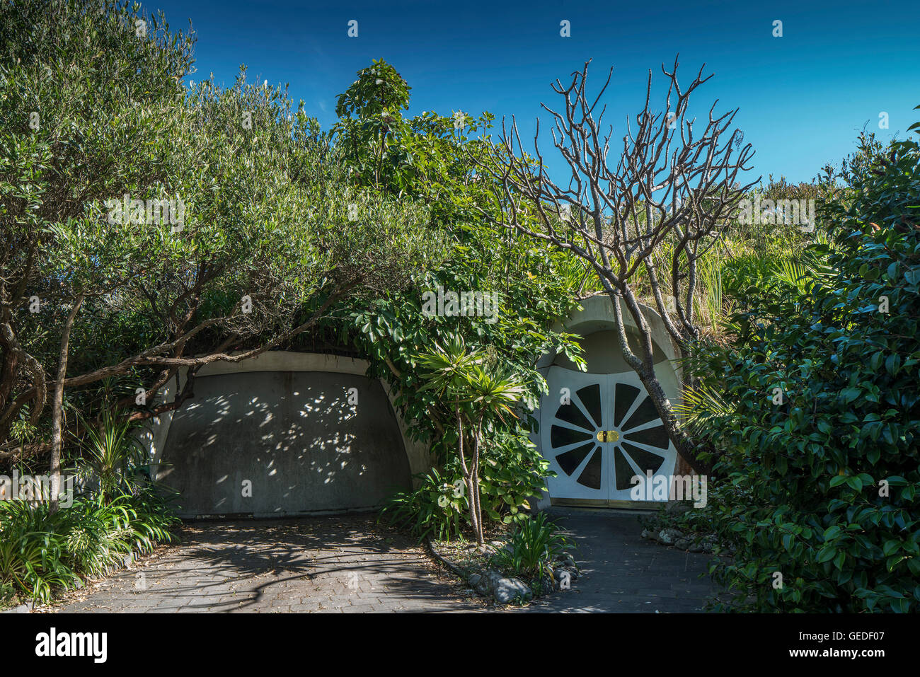 Porte avant et porte du garage couvert de verdure. Eco Dome, Peka Peka, Nouvelle-Zélande. Architecte : Fritz Eisenhofer, 1985. Banque D'Images