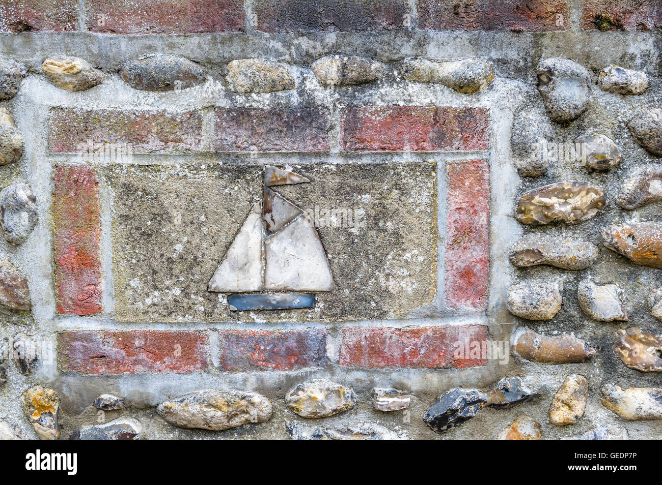 Bateau à voile faite en céramique monté dans un mur de briques et silex à Norfolk, en Angleterre. Banque D'Images