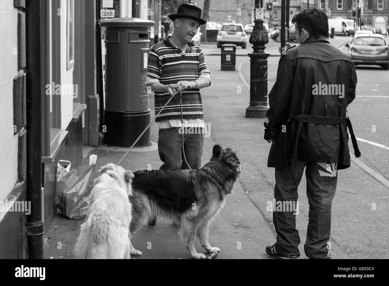 Deux hommes passer le temps de la journée à partir de la rue Haute, Buxton, Derbyshire, Angleterre. Version noir et blanc Banque D'Images