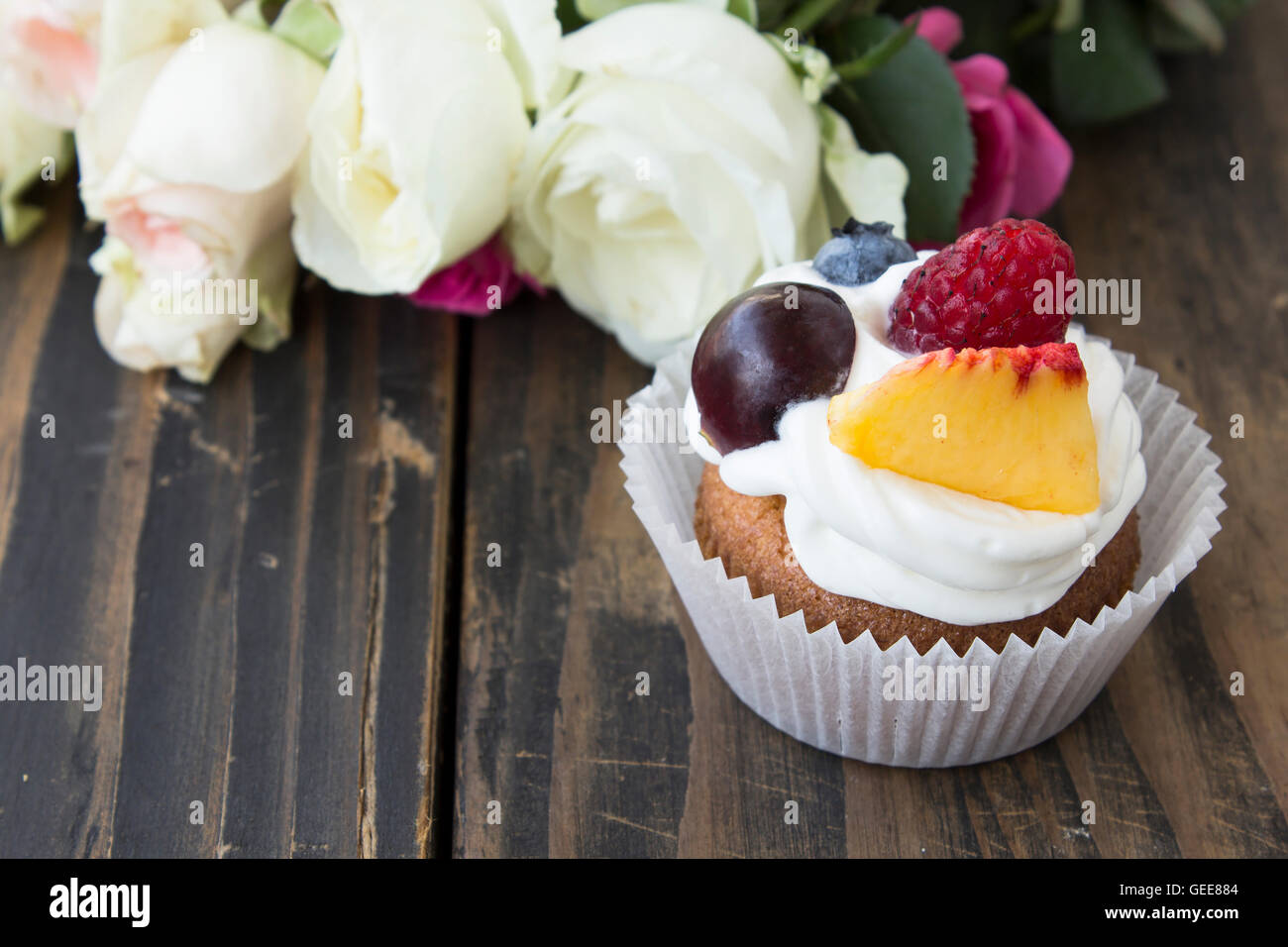 Cupcake délicieux avec des fruits et des fleurs. Banque D'Images
