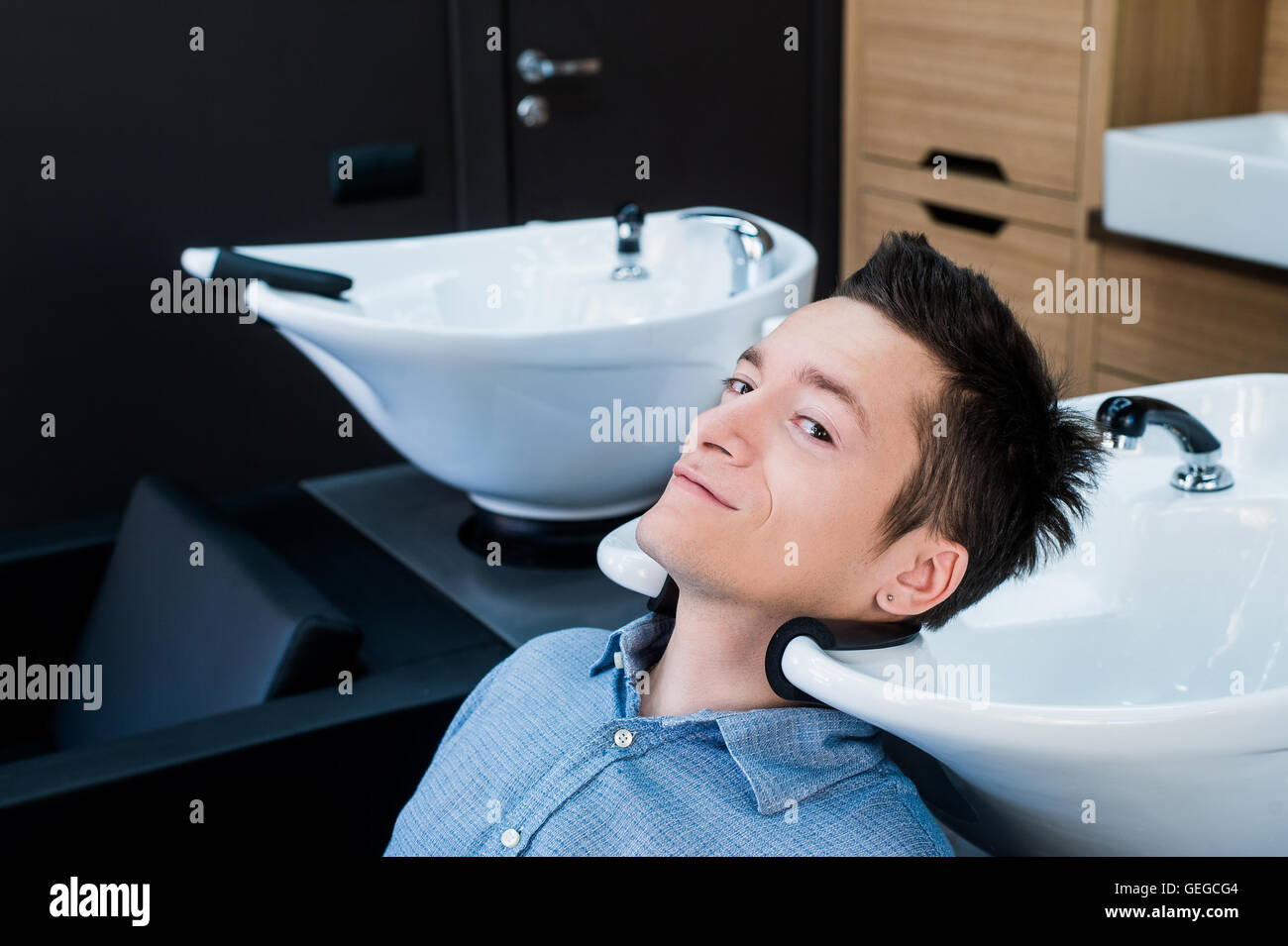 Vue de profil d'un jeune homme se préparer pour ses cheveux lavés Banque D'Images