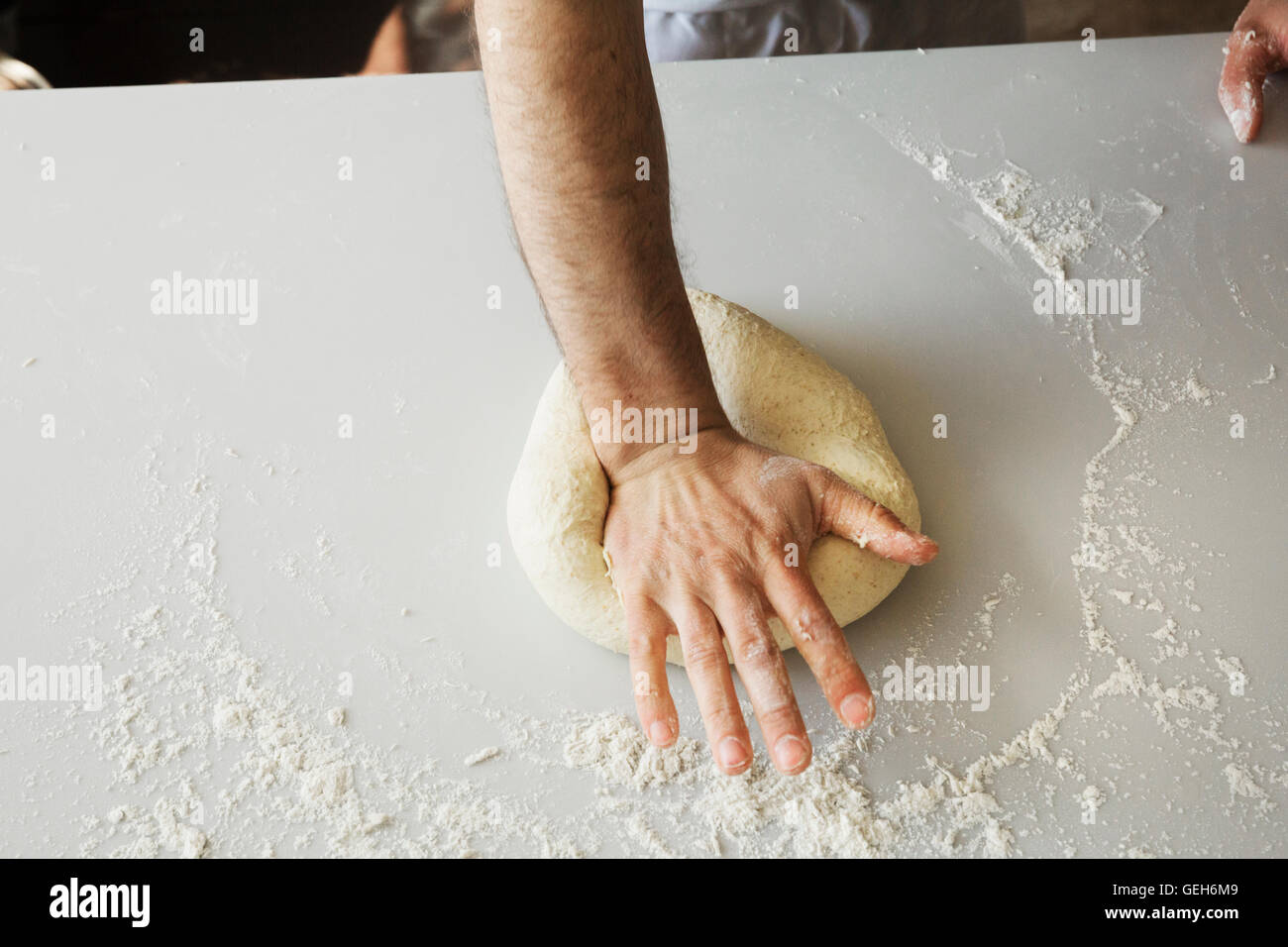 Close up of a baker le pétrissage et le façonnage de la pâte à pain en boule. Banque D'Images