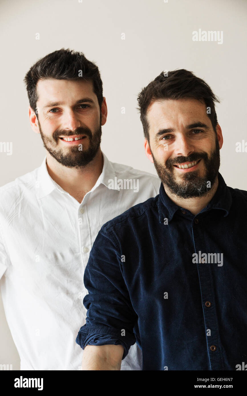 Portrait de deux hommes barbus souriant à la caméra. Banque D'Images