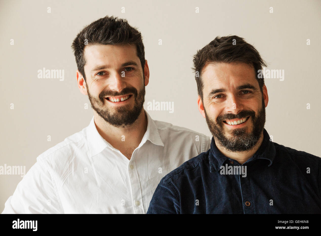 Portrait de deux hommes barbus souriant à la caméra. Banque D'Images