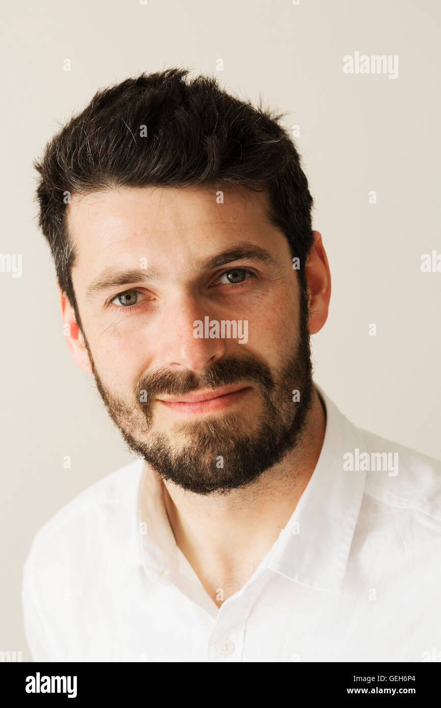 Portrait d'un homme barbu souriant à la caméra. Banque D'Images