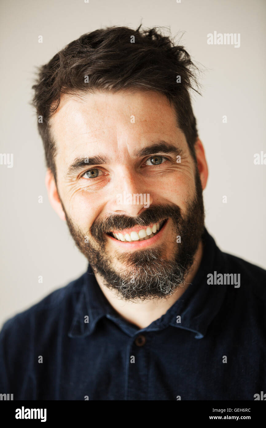 Portrait d'un homme barbu souriant à la caméra. Banque D'Images