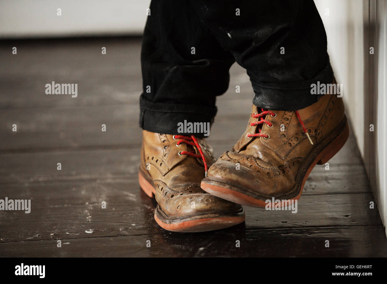 Close up of a man's pieds, portant des chaussures marron avec des lacets rouges. Banque D'Images