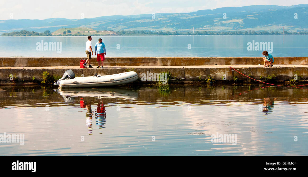 Golubac, Serbie - Juin 05, 2016 : deux hommes en attente de la troisième d'attacher le bateau à moteur gonflable sur le Danube, Pier Banque D'Images