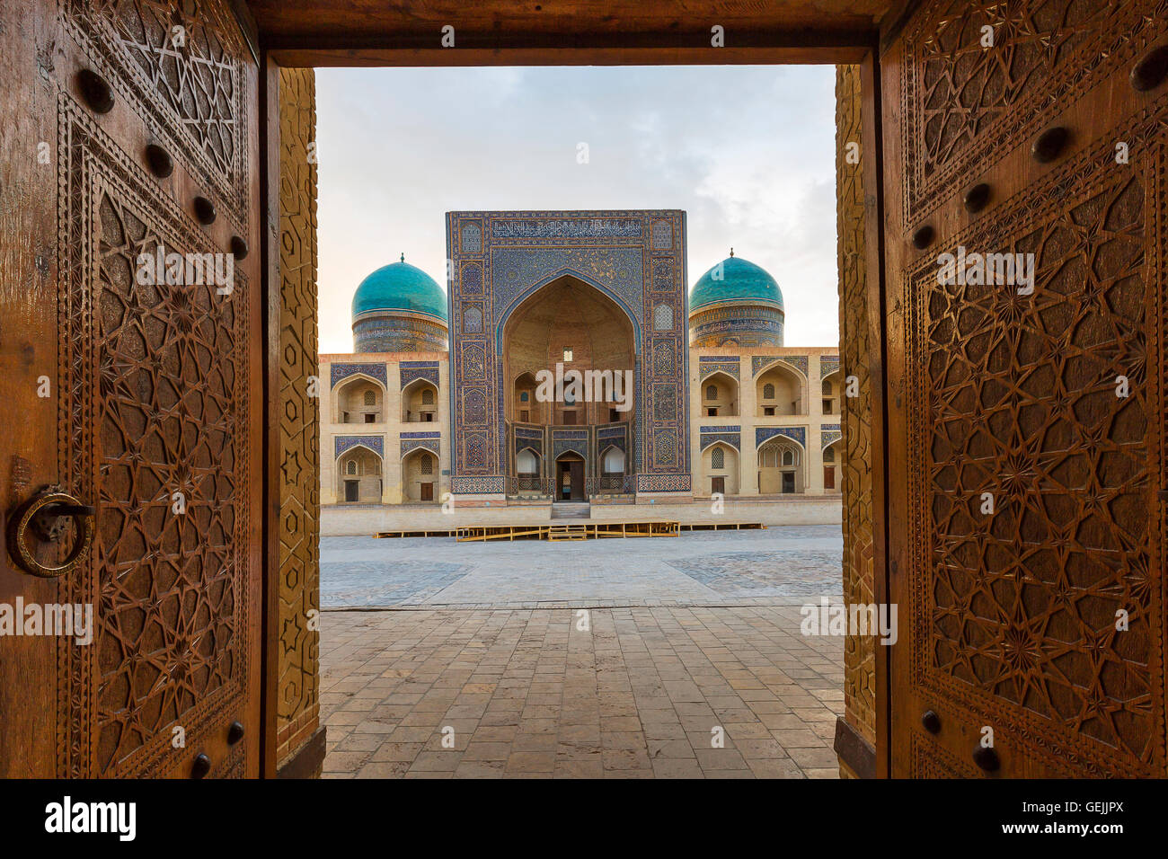 POI Kalon Madrassa à travers les portes en bois sculpté à Boukhara, Ouzbékistan. Banque D'Images