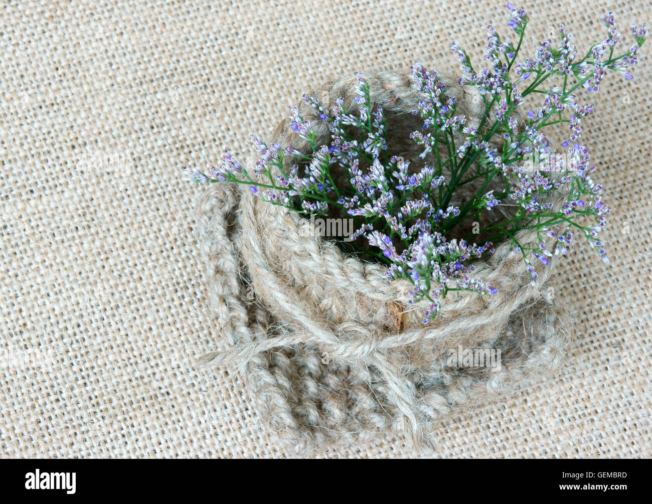 Idée étonnante décoration à la main par produit, pot de fleurs, forme de coeur de bonneterie à corde, belle fleur sur fond de toile, de l'utilisation Banque D'Images