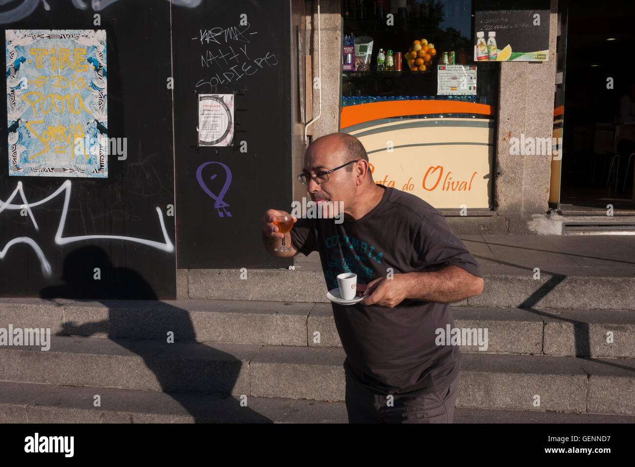 Un homme se fait passer pour quelqu'un sip wine en revenant d'un café à Porto, Portugal. Banque D'Images