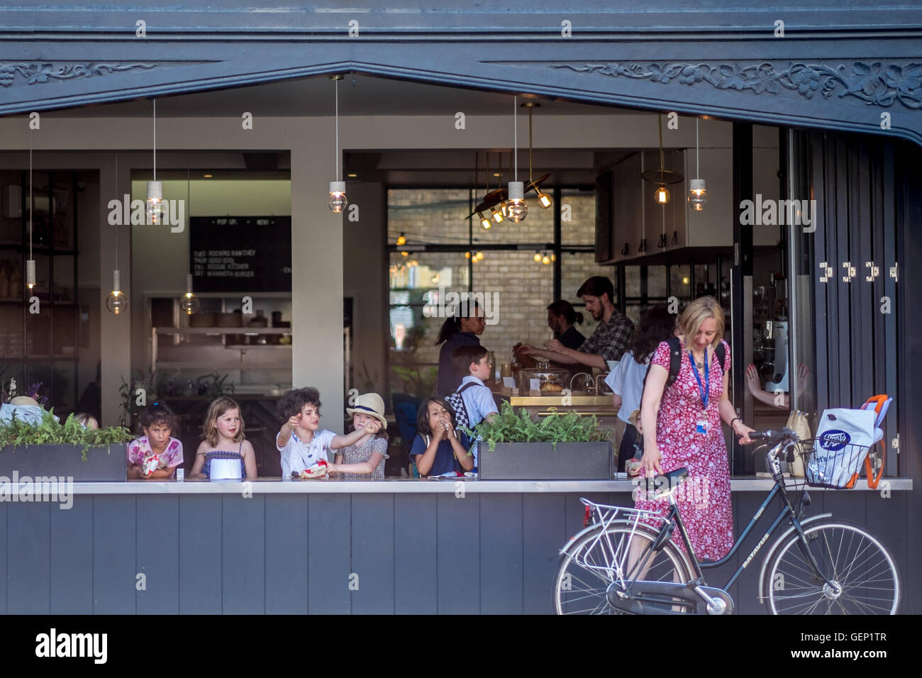 Les enfants prendre une collation dans un café en plein air dans la région de Cambridge. Banque D'Images