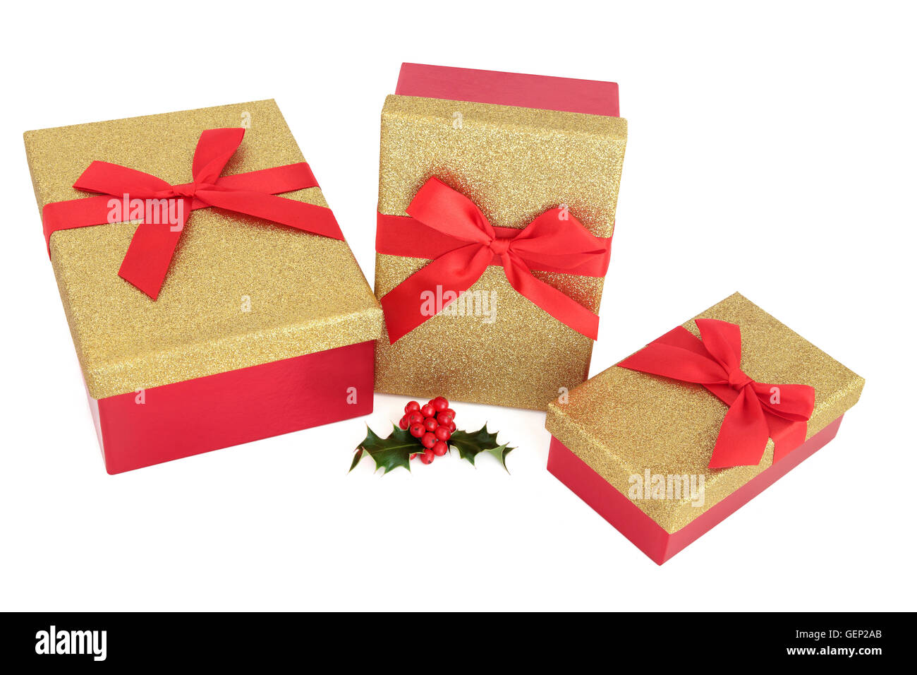 Cadeaux de Noël rouge avec des arcs et de houx sur fond blanc. Banque D'Images