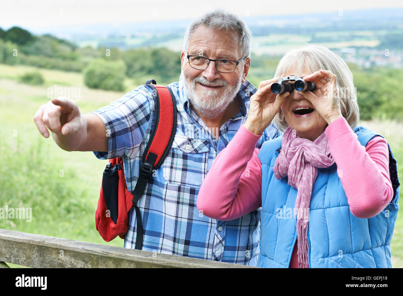 Senior Couple Hiking in Countryside Binoculars Banque D'Images