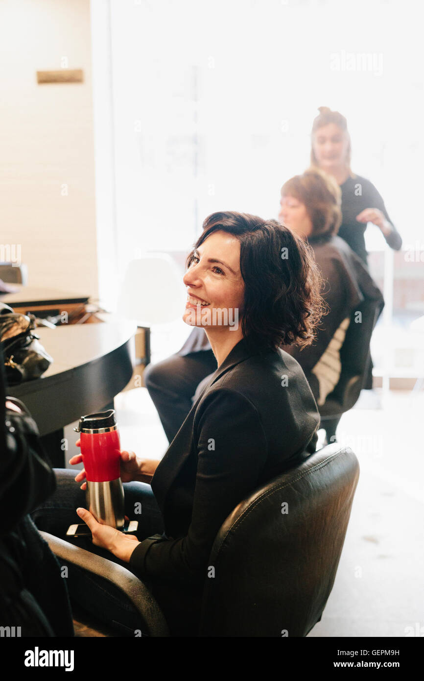 Un client assis dans un salon de coiffure. Banque D'Images