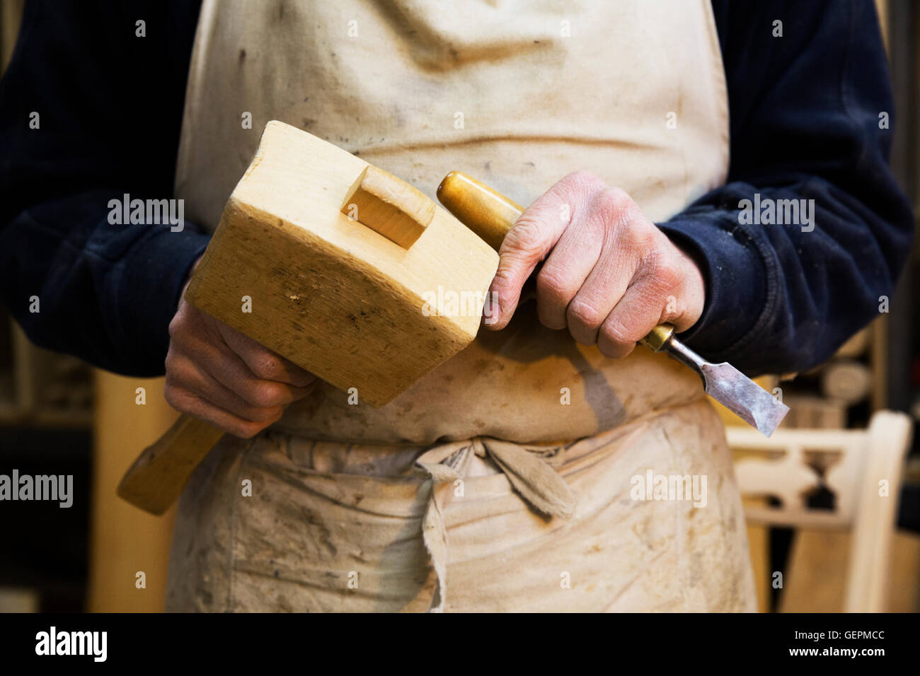 Portrait d'un homme dans un atelier de menuiserie, tenant un maillet en bois et d'un burin. Banque D'Images