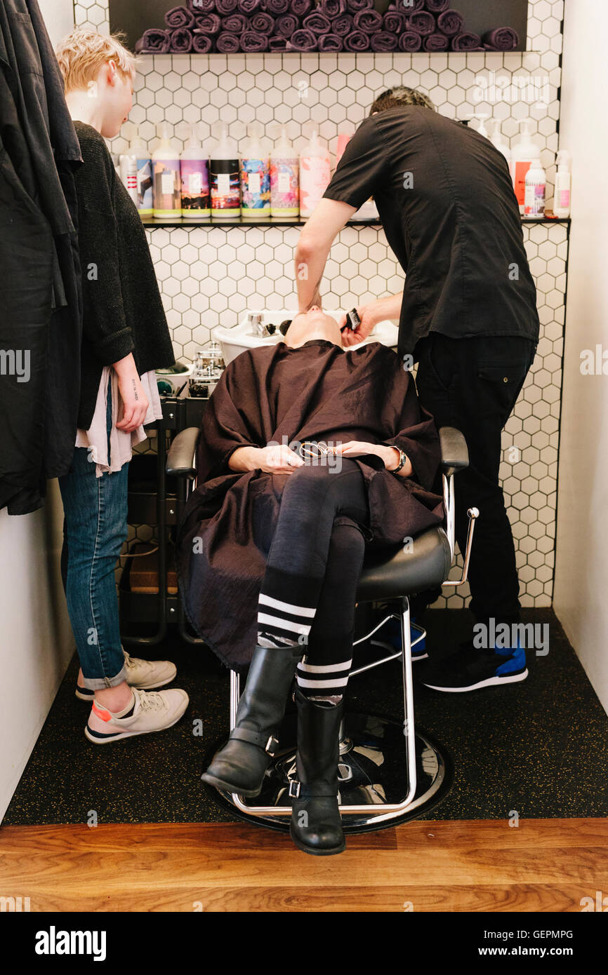 Un client à un salon de coiffure d'avoir ses cheveux lavés. Banque D'Images