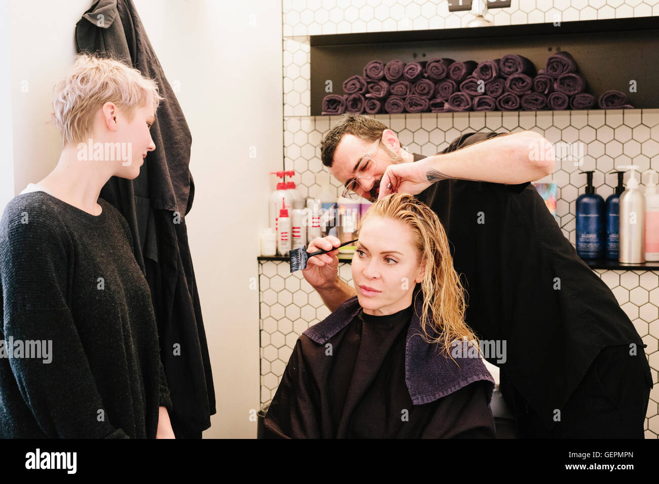 Un coiffeur couper les cheveux d'une femme dans un salon de coiffure. Banque D'Images