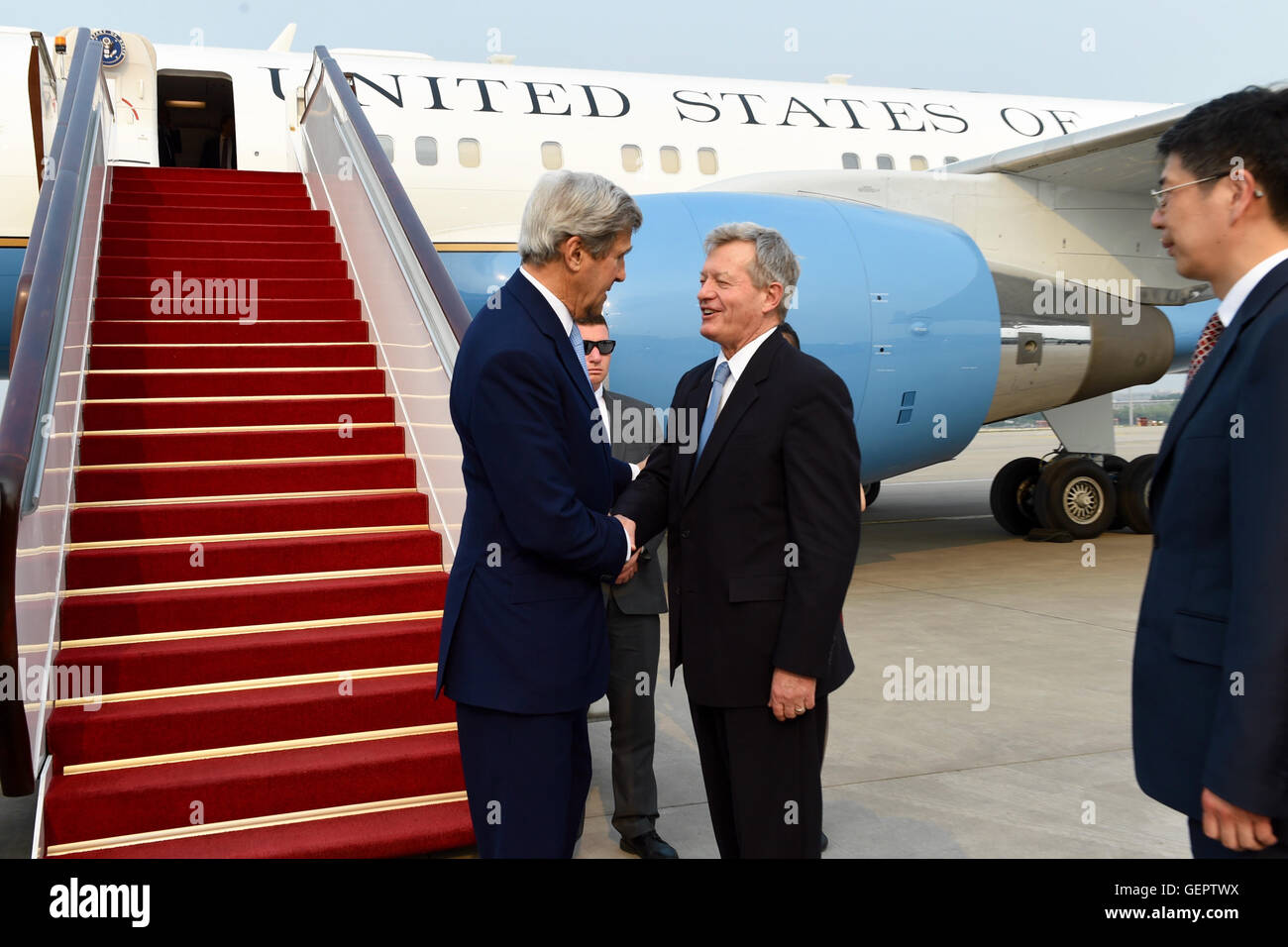 Kerry secrétaire est accueilli par l'Ambassadeur des États-Unis, Baucus à son arrivée à Beijing pour les États-Unis-Chine dialogue économique et stratégique Banque D'Images