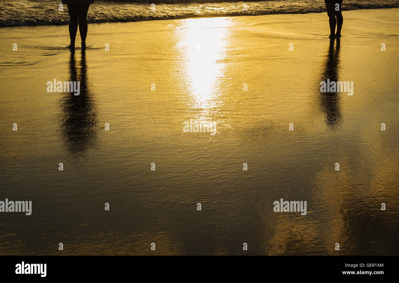 Coucher de soleil plage de la mer avec certaines personnes vous détendre dans le crépuscule sur la lumière du soleil et de tons sombres Banque D'Images
