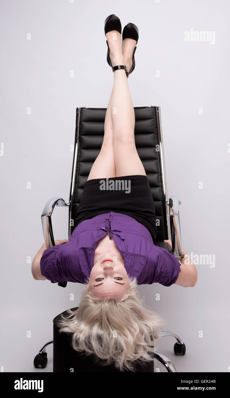 SECRÉTAIRE ET PRÉSIDENT DU BUREAU . Une secrétaire prenant du temps avec  ses jambes exercice d'étirement sur le dos d'une chaise de bureau Photo  Stock - Alamy