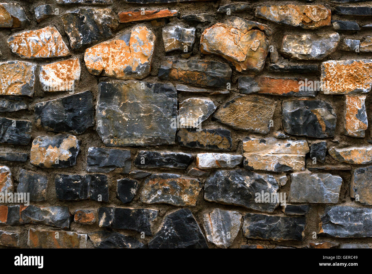 La texture de pierre mur de granit pour l'arrière-plan. Pierres monolithiques sombre rejoint avec du ciment dans un seul panneau de pierre. Greek Banque D'Images