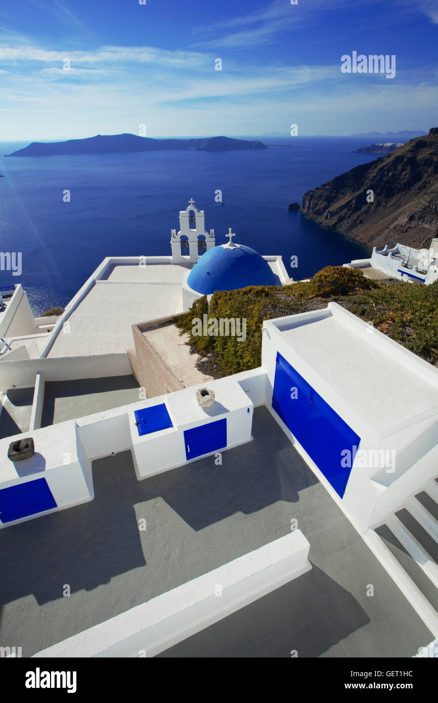 Vue d'un célèbre église au dôme bleu avec la caldeira et la mer au-delà. Banque D'Images