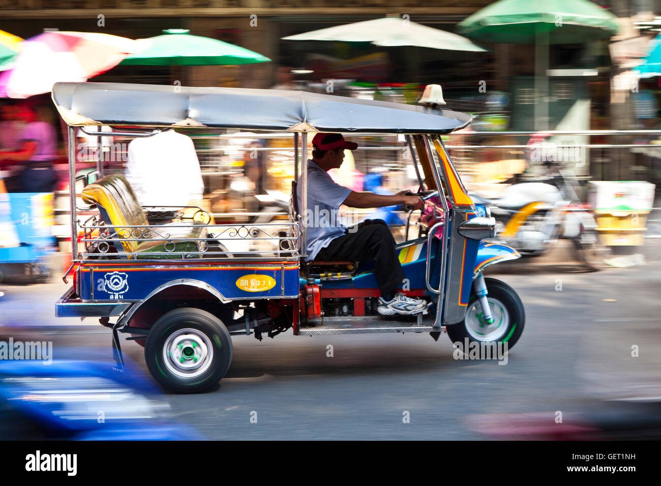 Un tuk tuk passant à travers les rues animées de Bangkok. Banque D'Images