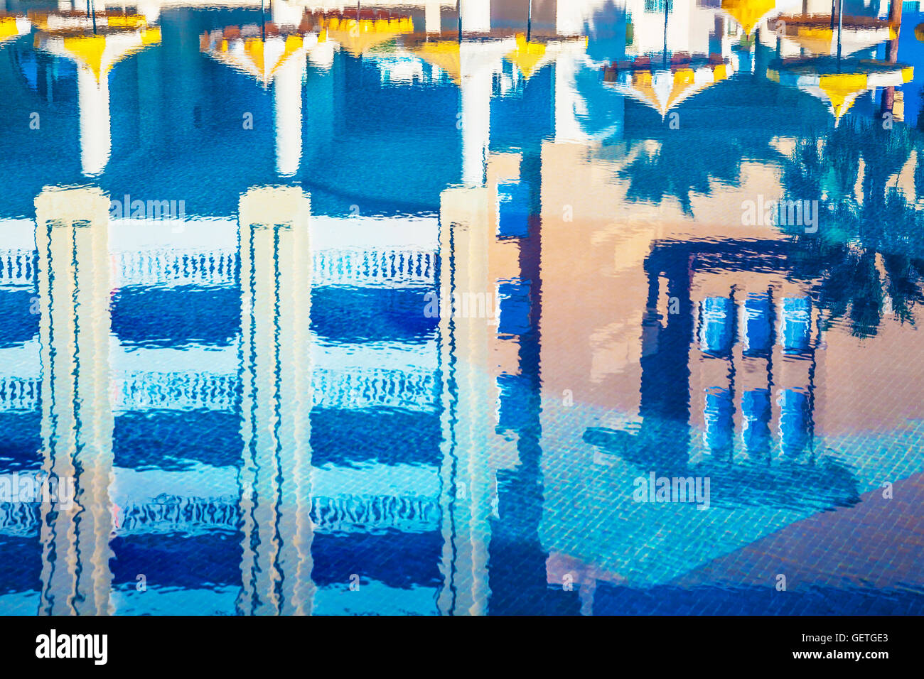 Réflexions de l'hôtel et des parasols autour de la piscine dans un établissement 5 étoiles près de Port el Kantoui en Tunisie. Banque D'Images
