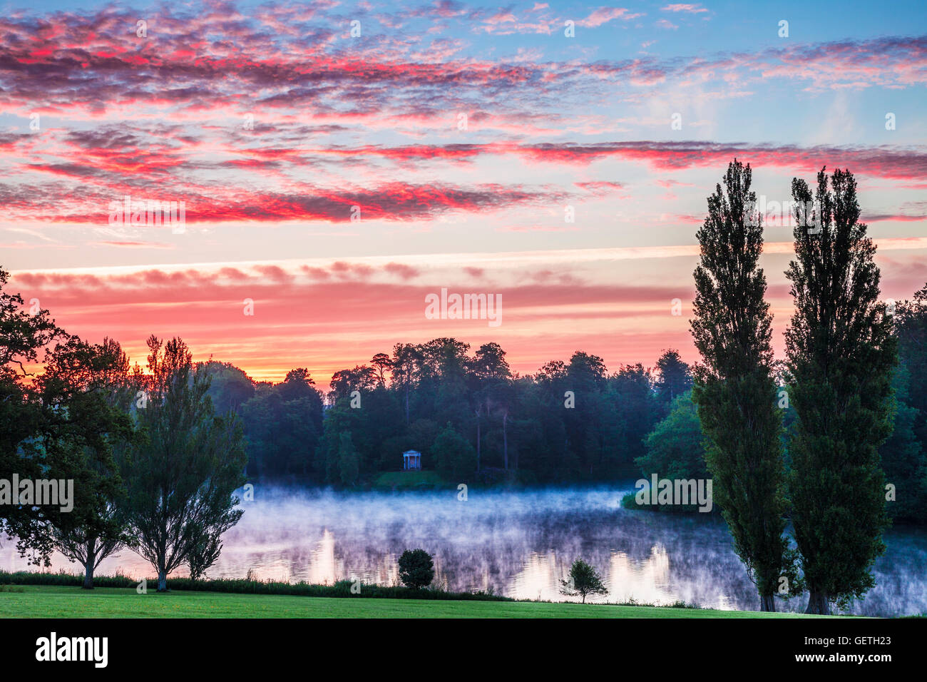 Le lever du soleil sur le temple dorique et le lac dans le parc de l'Bowood Estate dans le Wiltshire. Banque D'Images