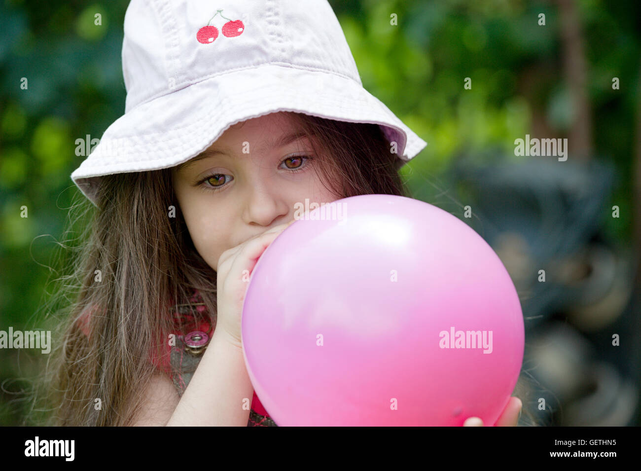 Portrait of Girl Blowing up balloon Banque D'Images