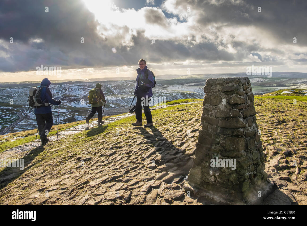 Les marcheurs à l'trig point sur le haut de Mam Tor sur un jour d'hiver lumineux. Banque D'Images