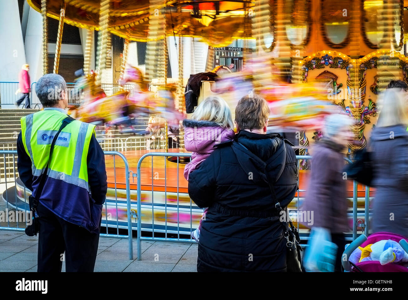 Les gens qui regardent un déménagement carrousel. Banque D'Images