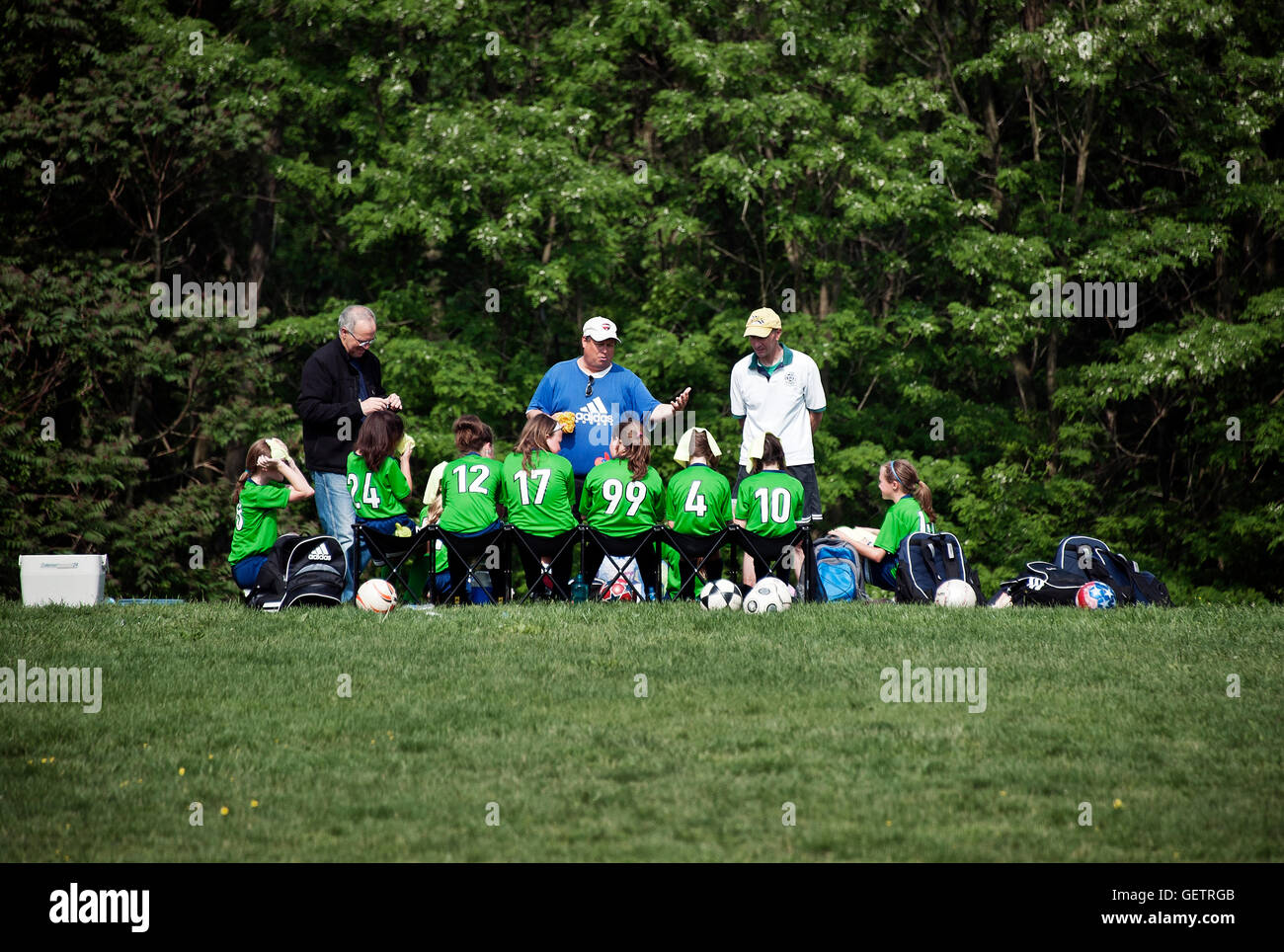 L'équipe de soccer pour les jeunes filles à la mi-temps avec l'entraîneur. Banque D'Images